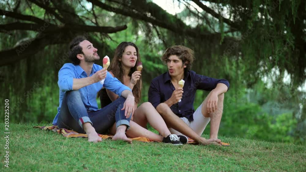 Friends Enjoying eating Ice Cream in Sunny Park- summer time Friends Enjoying eating Ice Cream in Sunny Park- summer time