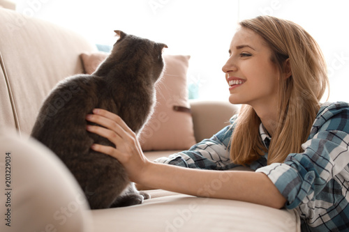 Young woman with her cute pet cat at home © New Africa