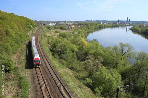 Landscape with railway and river. Railway line near river Nemunas in Lithuania. photo