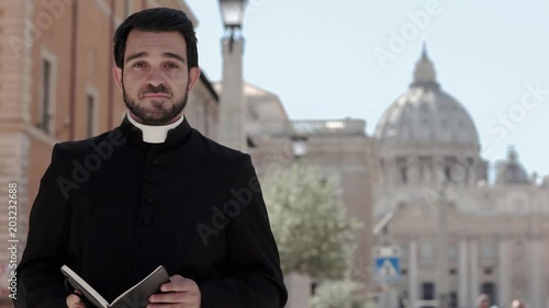 Peaceful and kind young priest smiling at the camera- Saint Peters Baslica photo