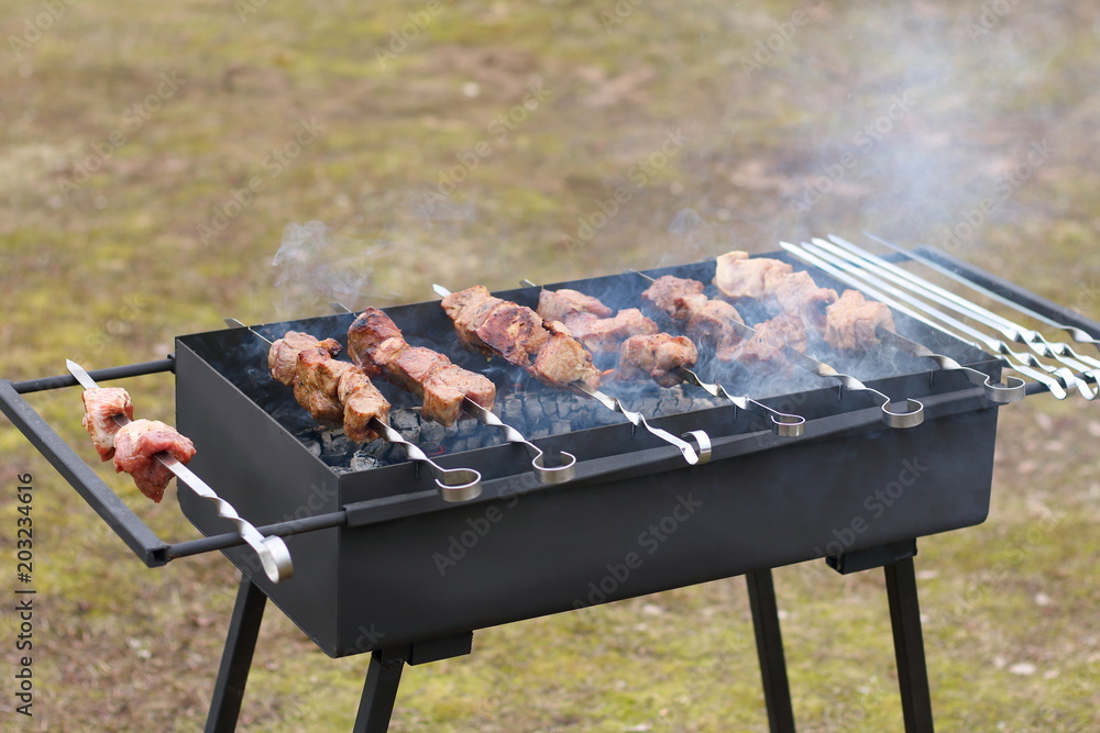 Meat on skewers fried on the grill in the garden. Meat on skewers fried on the grill in the garden.