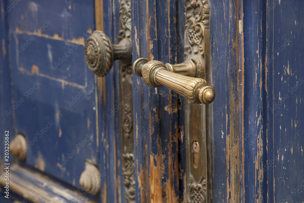 Brass door handle on old blue front door Brass door handle on old blue front door