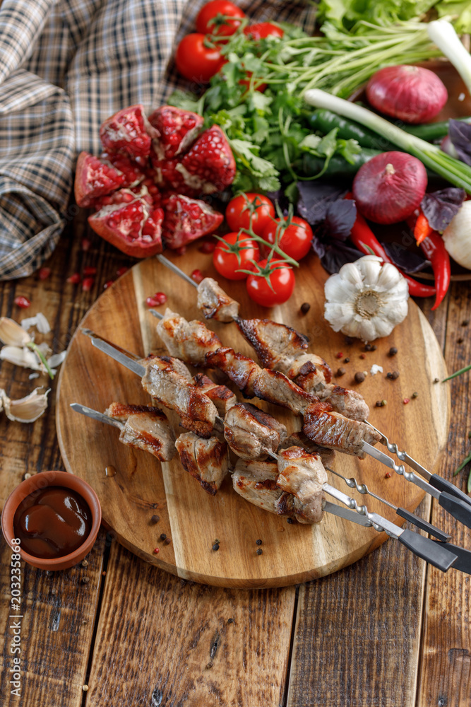 Shish kebabs cooked on an open fire. Still life with textiles on a wooden background.