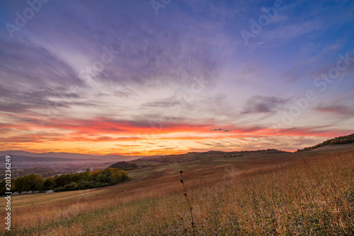 Romantic, bright and colorful sunset over a mountain range in Transilvania. Beautiful, colorful autumn background © lainen