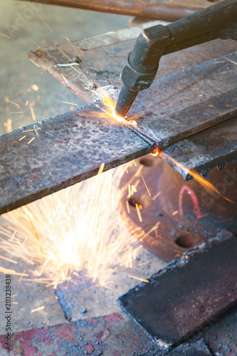 the worker cutting steel with an industrial cutter.