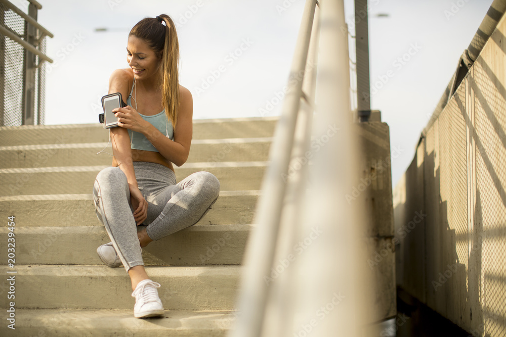 Young female runner resting on the stairs