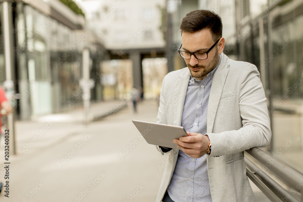 Young businessman with digital tablet by the office building Young businessman with digital tablet by the office building