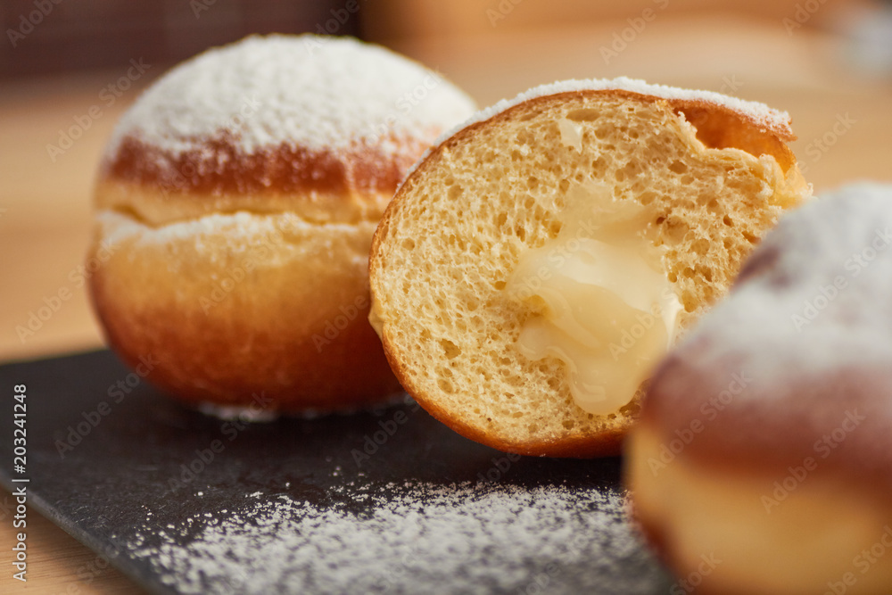 sweet donut sprinkled with powdered sugar on a plate closeup