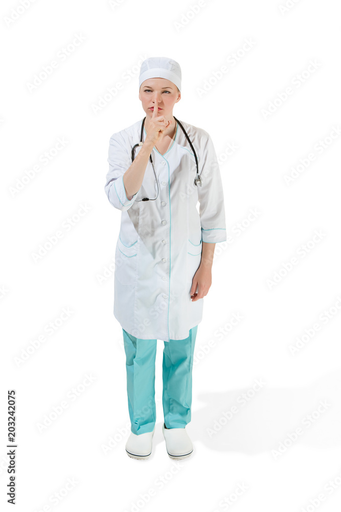 Beautiful young woman is whispering a secret in white coat posing at studio. Full length studio shot isolated on white. Beautiful young woman is whispering a secret in white coat posing at studio. Full length studio shot isolated on white.