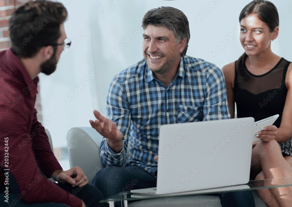 Portrait of smiling executives sitting with laptop in office Portrait of smiling executives sitting with laptop in office