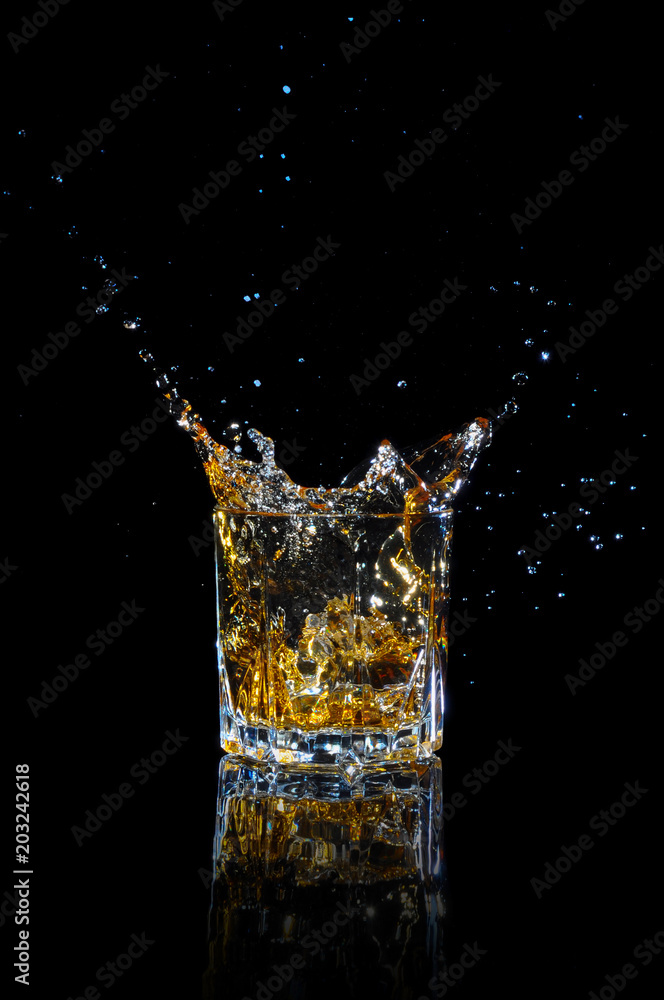 Whiskey with splash on black background. Whiskey with splash on black background.