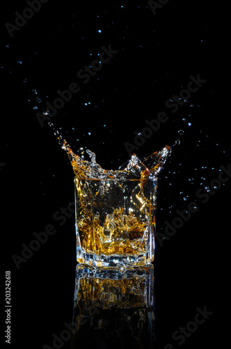 Whiskey with splash on black background.