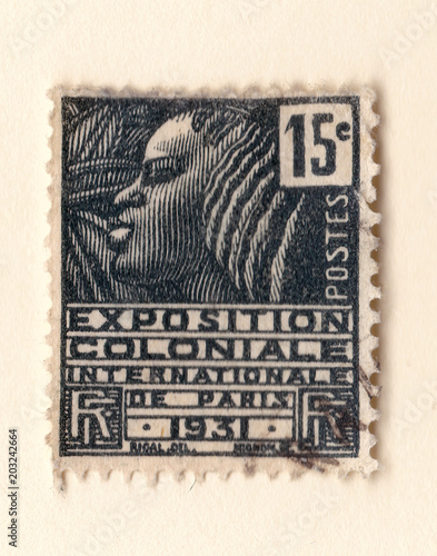 An old black french postage stamp with an illustration of a stylized african woman commemorating a colonial exhibition in 1931