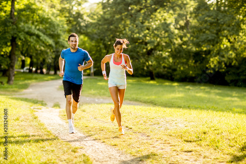 Young couple running in the park on a sunny day