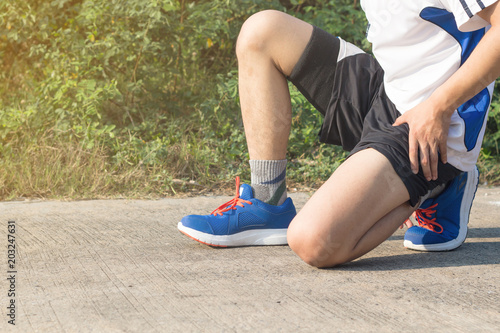 Young asian athlete man tying running shoes in front house,male runner ready for jogging on the road outside,wellness and sport concepts