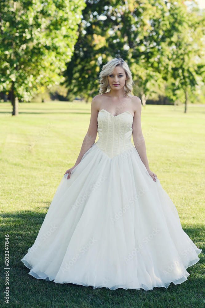 young woman in the park wearing yellow ball gown