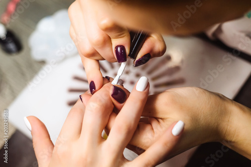 Woman hands in a nail salon receiving a manicure. Close up  selective focus. Top view
