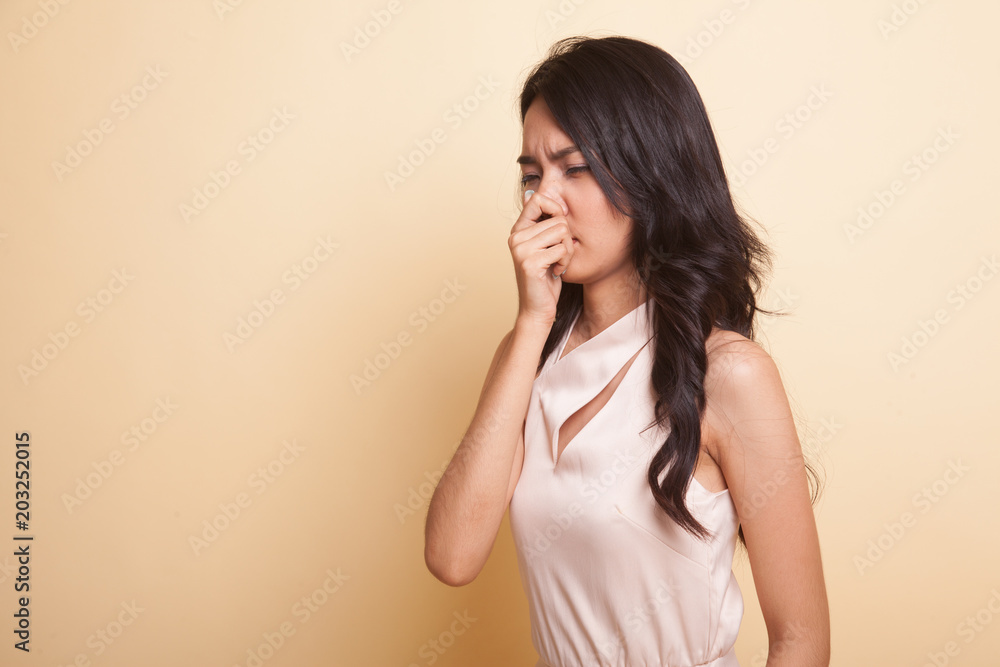 Young Asian woman holding her nose because of a bad smell. Young Asian woman holding her nose because of a bad smell.