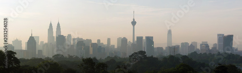 panorama view of beautiful kuala lumpur cityscape skyline in the hazy or foggy morning enviroment and buildings in silhouette photo