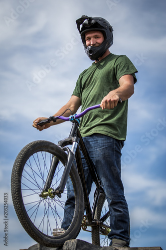 Sportsman in helmet standing on the bike