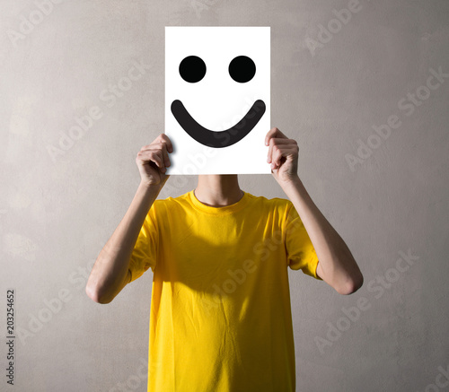 persona che tiene davanti al viso un foglio felice