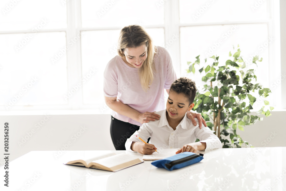 mother help Black boy doing homework at home mother help Black boy doing homework at home
