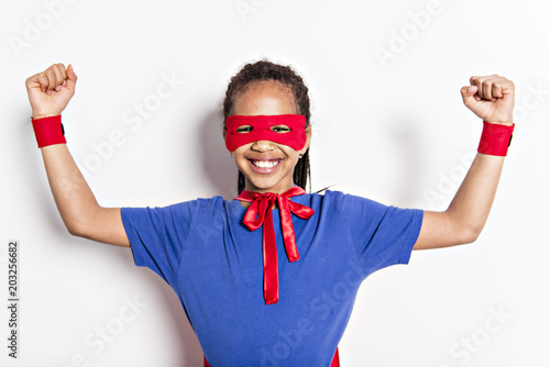 Portrait of girl in superhero costume against grey background photo