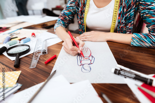 Fashion designer drawing model on paper.