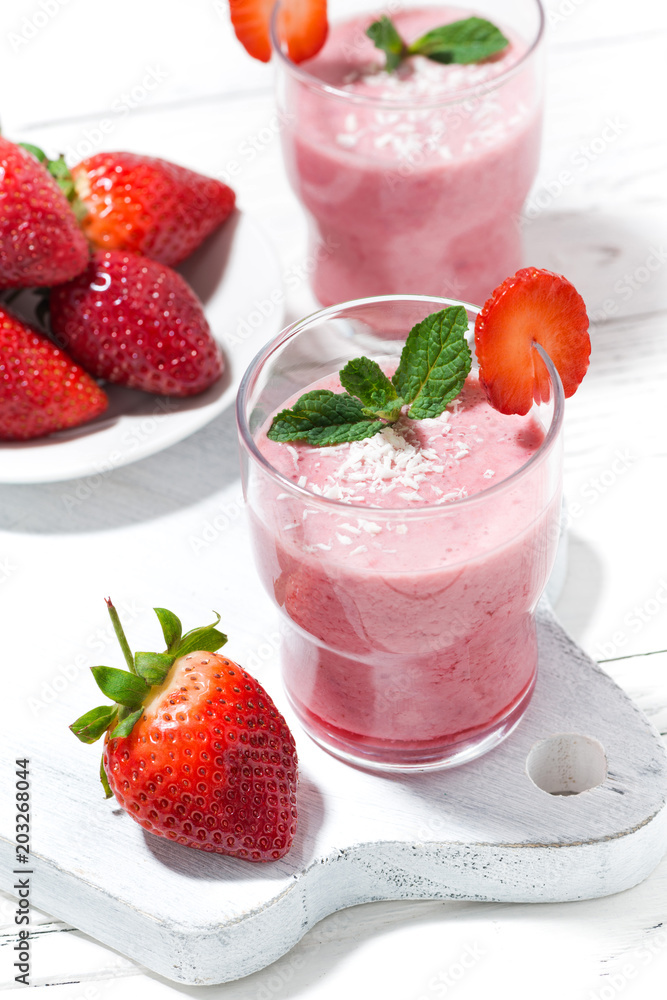 refreshing strawberry milkshake on white table, vertical top view refreshing strawberry milkshake on white table, vertical top view