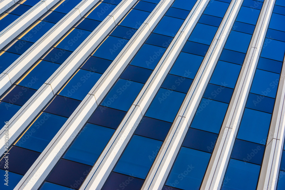 Glass and metal exterior facade of a modern architectural highrise building.