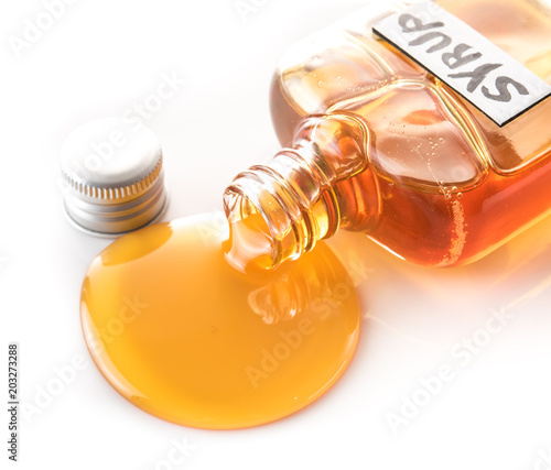 Maple syrup bottle pouring on white background