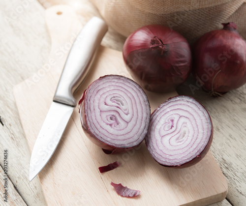 Red Onion Slices with wooden board on table wood