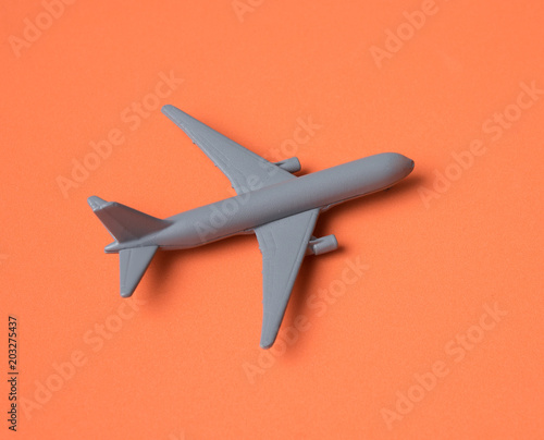 Gray Miniature toy airplane on orange background