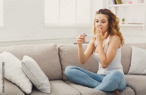 Surprised girl reading results of pregnancy test