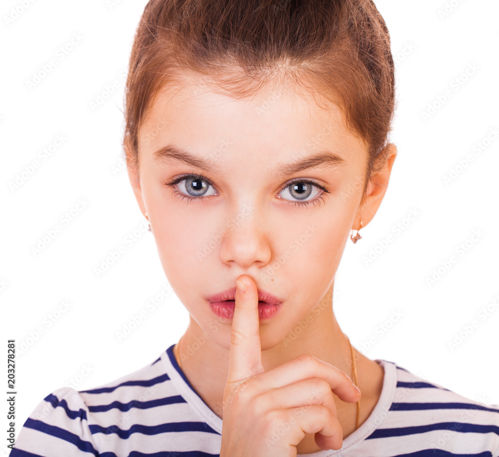 Little girl has put forefinger to lips as sign of silence Little girl has put forefinger to lips as sign of silence