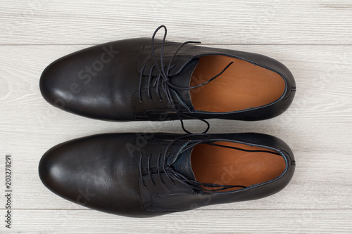 Pair of black leather men's shoes on grey wooden background