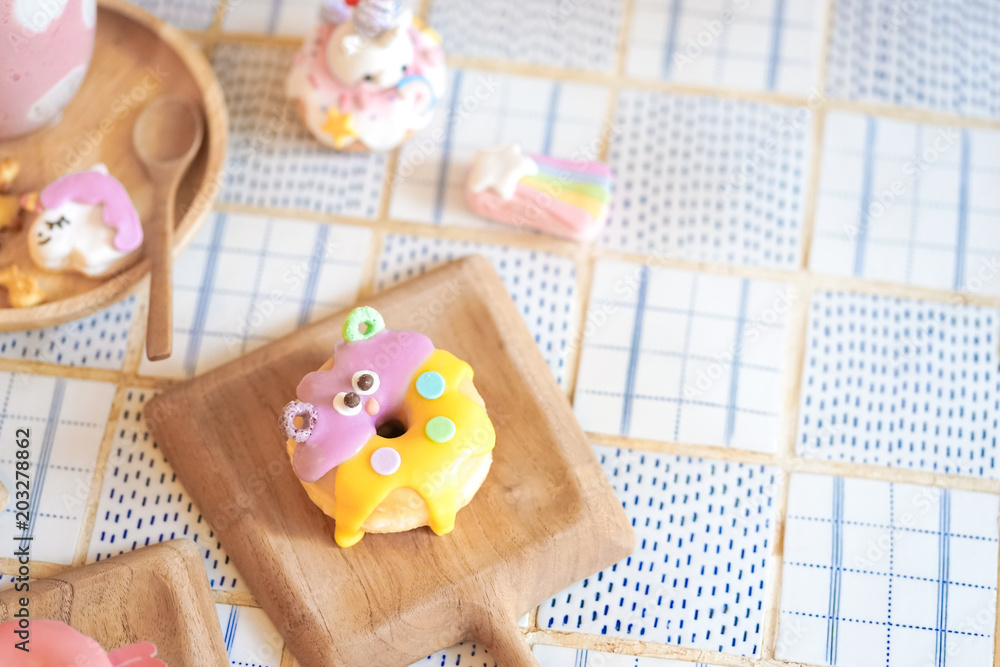 Cute donut. A cute monster sugar glazed doughnut served on a wooden table, soft focus. Fancy food concept for birthday or creative party. Cute donut. A cute monster sugar glazed doughnut served on a wooden table, soft focus. Fancy food concept for birthday or creative party.