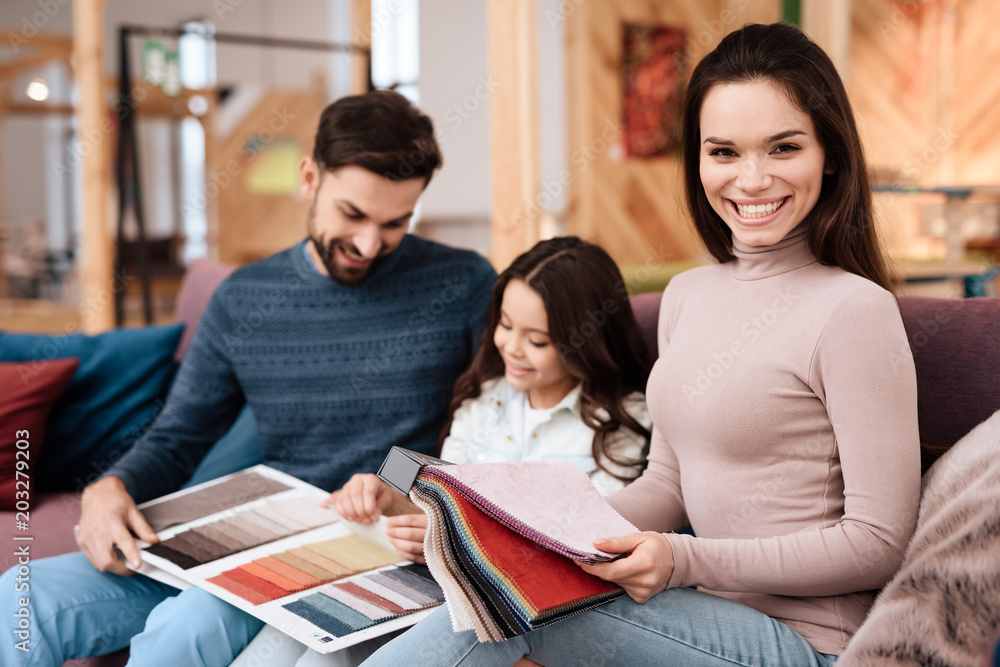 A young family with a little girl is choosing a new sofa. A young family with a little girl is choosing a new sofa.
