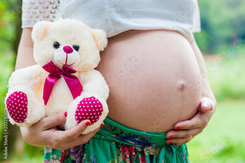 Pregnant mother holding her teddy bear in her hands - pregnancy photo