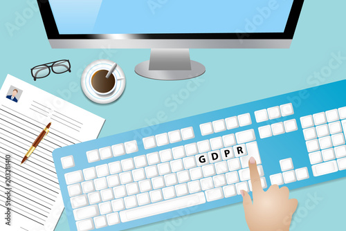 Top view of the office desk with coffee cup, Curriculum vitae paper with pen, computer monitor and keyboard. Hand is touching keyboard with inscription GDPR (General Data Protection Regulation)