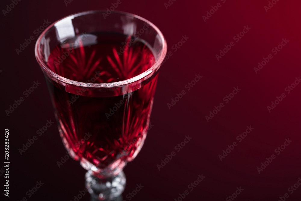 Close-up of crystal glass with red wine on dark background. Close-up of crystal glass with red wine on dark background.