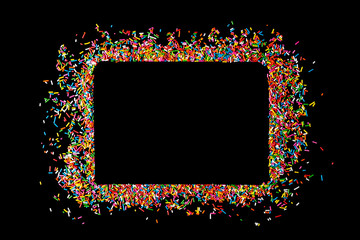 Border frame of colorful sprinkles on a black background with copy space. Top view or flat lay. Concept design for banner, poster and card