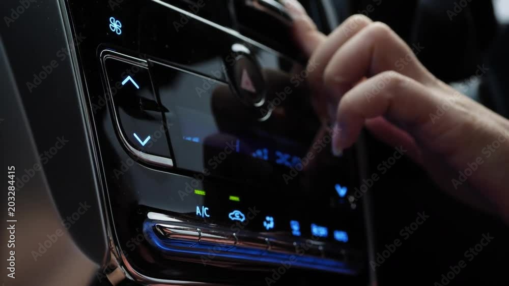 female using air control panel inside car female using air control panel inside car