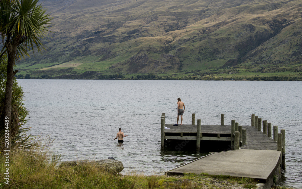 Two young men swimming in lake