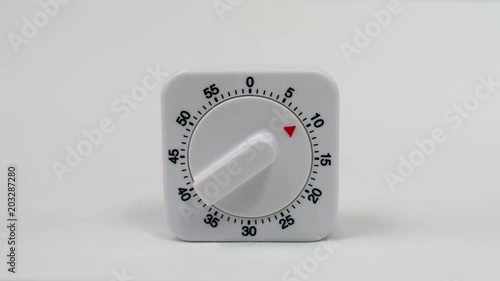 Egg timer / kitchen alarm clock in white plastic on white background ticking down from 10min. - timelapse photo