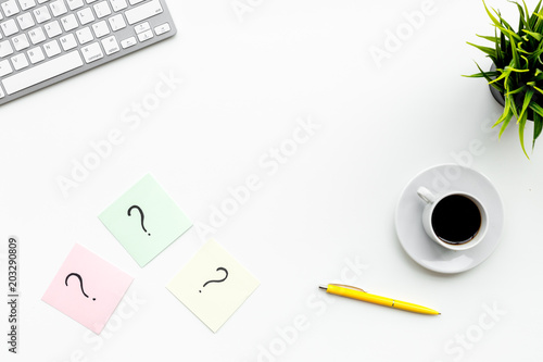 Question mark on sticky notes on office desk on white background top view copy space. FAQ concept. Working with clients. Troubles in work.