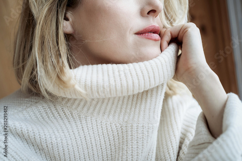 Mid section of woman with white sweater at home photo