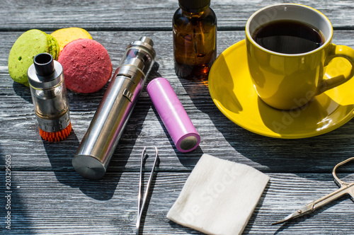 Still life with e-cig and jiuce on the wooden background photo