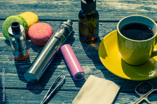 Still life with e-cig and jiuce on the wooden background photo