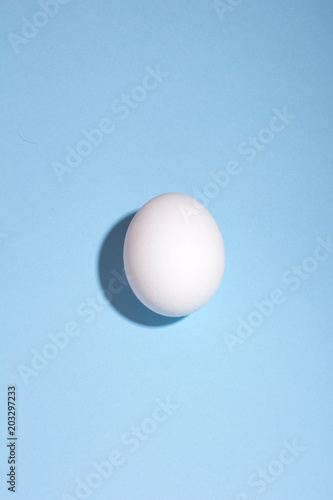 white egg with deep shadow on a blue background